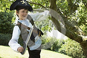 Boy In Pirate Costume Swinging From Tree