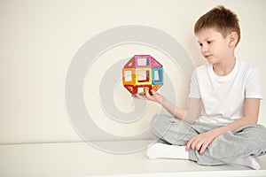 Boy plaing in a magnetic colorfull constructor