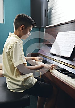 Boy plaing the piano at music lesson