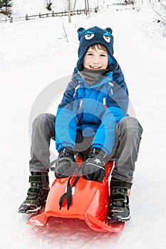 A boy on the plastic sledge