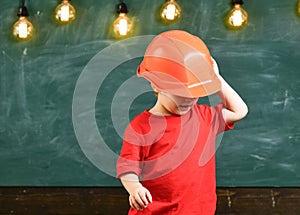 Boy play as builder or architect. Child dreaming about future career in architecture or building. Kid boy in orange hard