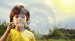 Boy play in bubbles in sunny summer day