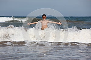 Boy play with ocean waves