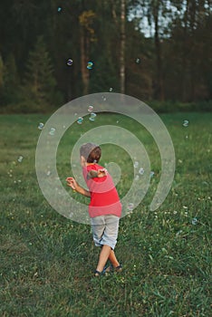 Boy play with soap bubbles in park