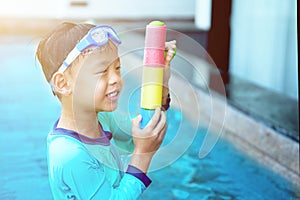 Boy play water gun with goggles in hotel vacation concept