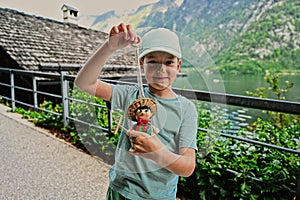 Boy play with wooden toy doll in Hallstatt, Austria