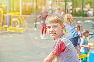 A boy on the playground, a portrait of a child against the backdrop of children`s swings and amusements