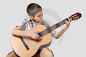 Boy is playing the acoustic guitar