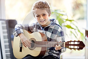 Boy playing acoustic guitar photo