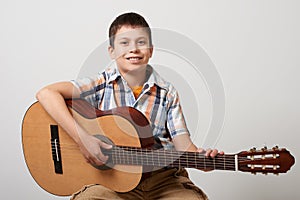 Boy is playing the acoustic guitar on white background