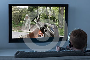 Boy Playing Action Game On Television