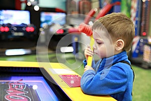 Boy playing arcade game with hammer