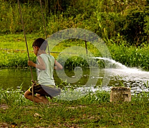 A boy playing on a balance near a lake