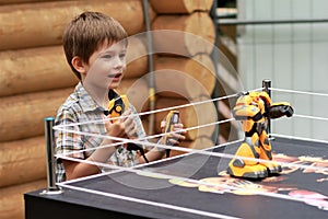 Boy playing battle fighting robot with remote control