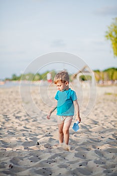 Boy playing on beach. Child play at sea on summer family vacation. Sand and water toys, sun protection for young child. Little boy