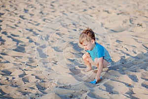 Boy playing on beach. Child play at sea on summer family vacation. Sand and water toys, sun protection for young child. Little boy