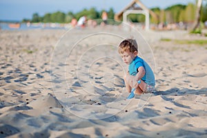 Boy playing on beach. Child play at sea on summer family vacation. Sand and water toys, sun protection for young child. Little boy