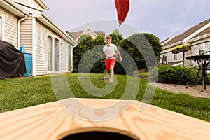 Boy playing bean bag toss in the backyard! photo