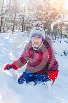 Boy playing in big snow in winter.