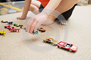 Boy playing with car collection on carpet.Child hand play. Transportation, airplane, plane and helicopter toys for children