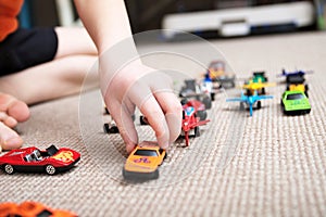 Boy playing with car collection on carpet.Child hand play. Transportation, airplane, plane and helicopter toys for children