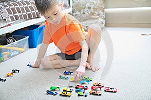 Boy playing with car collection on carpet.Child play home. Transportation, airplane, plane and helicopter toys for children