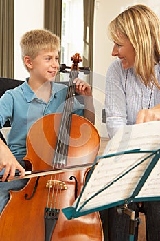 Boy playing cello in music lesson