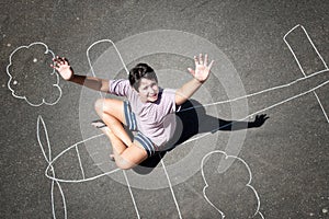 Boy playing in a chalk airplane