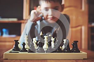 Boy playing chess in the children`s room
