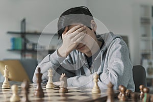 Boy playing chess and losing the game