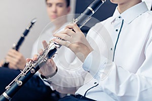 Boy playing the clarinet.A man hands holding clarinet