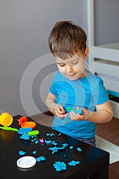 Boy playing with colorful clay molding in your room