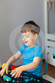 Boy playing with colorful clay molding in your room