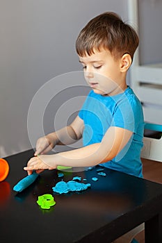 Boy playing with colorful clay molding in your room