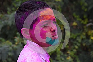 Boy playing with colors, In a happy mood. Concept for Indian festival Holi