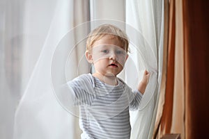 Boy playing with curtains