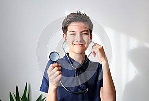 A boy playing doctor with stethoscope, isolated on light background.