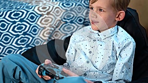 Boy playing with dog in the house on the couchHands holding the game controller while boy child playing game on TV in a room