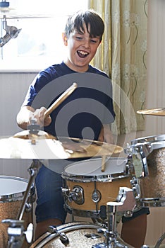 Boy Playing Drum Kit At Home