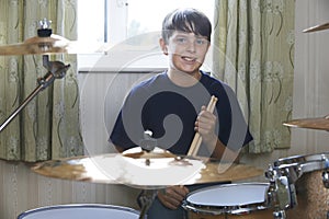 Boy Playing Drum Kit At Home