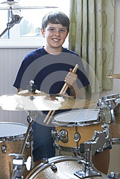 Boy Playing Drum Kit At Home