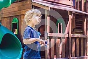 Boy playing with fidget spinner. Child spinning spinner on the playground. Blurred background