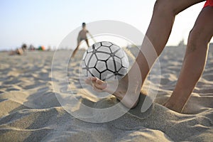 Boy playing football on the beach