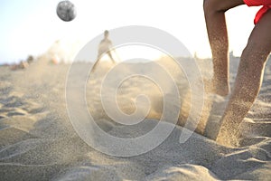 Boy playing football on the beach