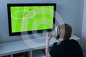 Boy Playing Football Videogame On Television