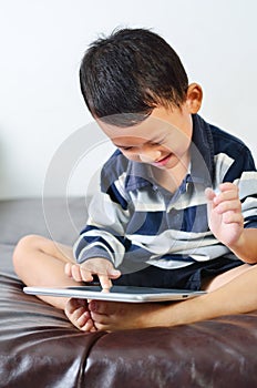 A boy playing a game on computer tablet