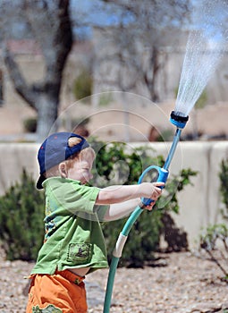 Boy playing with garden hose