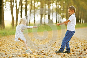 Boy playing with a girl in autumn country road