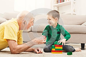 Boy playing with grandfather in building kit