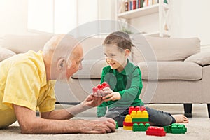 Boy playing with grandfather in building kit